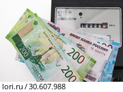 Показания квартирного электросчетчика с купюрами на оплату счета. Стоковое фото, фотограф Кузин Алексей / Фотобанк Лори