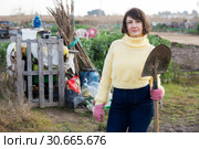 Girl in a yellow sweater digs beds with a shovel. Стоковое фото, фотограф Яков Филимонов / Фотобанк Лори