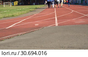 Blurred background of runners on provincial stadium. Amateur sport footage slow. Стоковое видео, видеограф Dmitry Domashenko / Фотобанк Лори