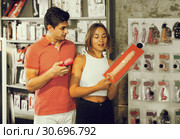 woman and man bayers choosing long rubber phallus in the sex sh. Стоковое фото, фотограф Яков Филимонов / Фотобанк Лори
