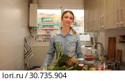 Smiling attractive girl standing at home kitchen interior, posing at camera. Стоковое видео, видеограф Яков Филимонов / Фотобанк Лори