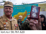 Ветераны Афганской войны держат в руках медаль "30 лет завершения выполнения задач 40 армией в Афганистане" на фоне карты Афганистана в Севастополе, 19 мая 2019 года. Редакционное фото, фотограф Николай Винокуров / Фотобанк Лори