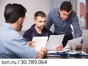 Three upset males with papers at table. Стоковое фото, фотограф Яков Филимонов / Фотобанк Лори