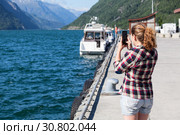 Женщина фотографирует фьорд на камеру смартфона. Одда, Норвегия (2018 год). Стоковое фото, фотограф Кекяляйнен Андрей / Фотобанк Лори