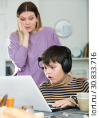 Upset mother arguing with son who plaing video games. Стоковое фото, фотограф Яков Филимонов / Фотобанк Лори