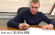 The office clerk writes the conclusion on paper and throws out the drafts. Стоковое видео, видеограф Aleksandr Sulimov / Фотобанк Лори