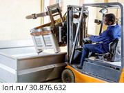 African American male worker controlling process of unloading grapes with forklift. Стоковое фото, фотограф Яков Филимонов / Фотобанк Лори