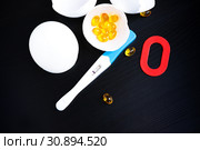 Infertility. Negative pregnancy test, pills, eggshell and number zero on black. Стоковое фото, фотограф Papoyan Irina / Фотобанк Лори
