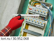 Electrician works with power rail in switchbox. current breaker installation. Стоковое фото, фотограф Дмитрий Калиновский / Фотобанк Лори