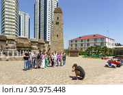 Группа туристов фотографируется на фоне фонтана с башнями около высотного комплекса "Грозный-Сити". Цветочный парк, Грозный, Чеченская Республика, Россия (2019 год). Редакционное фото, фотограф Наталья Гармашева / Фотобанк Лори