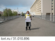 Женщина-активистка стоит с плакатами в одиночном пикете в центре города Красноярска (2019 год). Редакционное фото, фотограф Светлана Попова / Фотобанк Лори