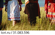 People in traditional russian clothes walking on the high grass. Стоковое видео, видеограф Константин Шишкин / Фотобанк Лори