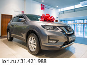 Новый Nissan X-Trayl (2019) с красным бантом в салоне официального дилера "Ниссан" крупным планом. Редакционное фото, фотограф Виктор Карасев / Фотобанк Лори