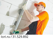Plasterer levelling screed on wall for plastering. Стоковое фото, фотограф Дмитрий Калиновский / Фотобанк Лори