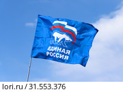Флаг партии "Единая Россия" на фоне ясного синего неба (2019 год). Редакционное фото, фотограф Ekaterina M / Фотобанк Лори