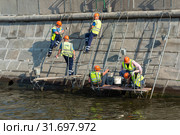 Рабочие ремонтируют гранитную набережную реки Москвы (2019 год). Редакционное фото, фотограф Александр Щепин / Фотобанк Лори