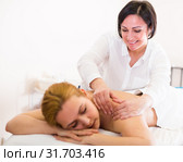 Aged massagist is doing relaxing massage shoulder area for young woman. Стоковое фото, фотограф Яков Филимонов / Фотобанк Лори