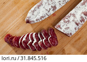 Slicing delicious Spanish smoked sausage fuete. Стоковое фото, фотограф Яков Филимонов / Фотобанк Лори