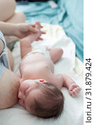 Breastfeeding, mother giving a baby the breast, infant laying on white bedsheet in bed. Стоковое фото, фотограф Кекяляйнен Андрей / Фотобанк Лори