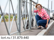 Mature casual dressed woman overcomes road barrier with her backpack. Urban highway. Стоковое фото, фотограф Кекяляйнен Андрей / Фотобанк Лори