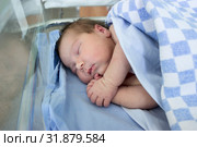 Newborn baby sleep in small hospital glass bed covered with blanket, arms crossed. Стоковое фото, фотограф Кекяляйнен Андрей / Фотобанк Лори