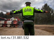Офицер Военной автомобильной инспекции уравляет движением колонны танков на военном полигоне "Алабино" , Московская область, Россия (2019 год). Редакционное фото, фотограф Николай Винокуров / Фотобанк Лори