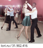 Positive adult couples dancing tango together in modern studio. Стоковое фото, фотограф Яков Филимонов / Фотобанк Лори