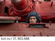Крупным планом танкист , который управляет танком Т-72Б3 во время  международных соревнований "Танковый биатлон-2019" на военном полигоне "Алабино", Россия. Редакционное фото, фотограф Николай Винокуров / Фотобанк Лори