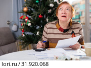 Mature woman calculates utility costs in the new year. Стоковое фото, фотограф Яков Филимонов / Фотобанк Лори