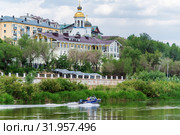Orenburg, Russia - June, 1, 2019: Motor boat on the Ural river. City landscape with the embankment and riverbanks. Редакционное фото, фотограф Вадим Орлов / Фотобанк Лори