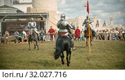 BULGAR, RUSSIA 11-08-2019: Knights with swords riding horses on the battlefield and crossing their swords - people watching behind the fence. Редакционное видео, видеограф Константин Шишкин / Фотобанк Лори