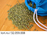 Close up of green mung bean vigna radiata in blue reusable package on wooden background. Eco packaging concept. Стоковое фото, фотограф Ольга Балынская / Фотобанк Лори