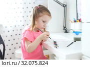 Cute little girl painting with brush at home. Стоковое фото, фотограф ivolodina / Фотобанк Лори