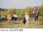 family picks up trash on the beach in summer. Стоковое фото, фотограф Майя Крученкова / Фотобанк Лори