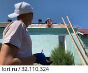Монтаж кровли, кровельщики перекрывают крышу на здании рулетка и карандаш в руке строителя. Стоковое фото, фотограф Кузнецов Максим / Фотобанк Лори