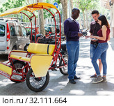 Pedicab driver negotiating with couple. Стоковое фото, фотограф Яков Филимонов / Фотобанк Лори