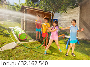 Friends play water gun fight in the garden. Стоковое фото, фотограф Сергей Новиков / Фотобанк Лори