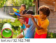 Water gun fight game with many kids in action. Стоковое фото, фотограф Сергей Новиков / Фотобанк Лори