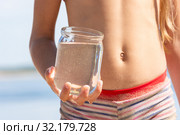 Банка с пресной речной водой в руке ребенка на пляже. Стоковое фото, фотограф Иванов Алексей / Фотобанк Лори