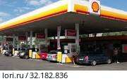 Drivers fill up their cars on the Shell petrol station in Stockholm city. Exterior of white and yellow building. Shell is largest oil company in the world. Sweden (2019 год). Редакционное видео, видеограф Кекяляйнен Андрей / Фотобанк Лори
