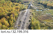 Вид осенью на старый железнодорожный мост железной дороги "Чум - Салехард - Игарка" сталинской 501-й стройки ГУЛАГ. Ямало-Ненецкий автономный округ (2018 год). Стоковое видео, видеограф Григорий Писоцкий / Фотобанк Лори