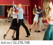 Positive adult couples dancing tango together in modern studio. Стоковое фото, фотограф Яков Филимонов / Фотобанк Лори