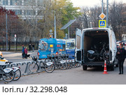 Станция проката велосипедов на Ботанической улице в Москве. Рядом стоит микроавтобус техобслуживания велопроката с распахнутыми задними дверями. В кузове видны велосипеды с маркировкой "ВТБ" (2019 год). Редакционное фото, фотограф Наталья Николаева / Фотобанк Лори