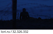 A soldier of World War II is sitting in the trench at night on patrol. Стоковое видео, видеограф Константин Шишкин / Фотобанк Лори