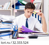 Businessman working in the office with piles of books and papers. Стоковое фото, фотограф Elnur / Фотобанк Лори