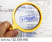 Штамп выдан кредит, оплачено, проверено охраной на кассовом чеке с фрагментом договора  о покупке, через лупу. Стоковое фото, фотограф Элина Гаревская / Фотобанк Лори