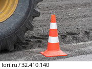Wheel with tire on road reclaimer during roadworks, traffic road cone on asphalt (2019 год). Редакционное фото, фотограф А. А. Пирагис / Фотобанк Лори