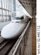 White high speed train N700 series of JR West waits passengers on Tokyo platform. The Tokaido Shinkansen line. It is Nozomi bullet train which stop at only the largest stations. Токио, Япония (2013 год). Редакционное фото, фотограф Кекяляйнен Андрей / Фотобанк Лори