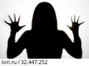 Черный силуэт длинноволосой девушки с вытянутыми руками и растопыренными пальцами, как в фильмах ужасов. Стоковое фото, фотограф Sergei Gorin / Фотобанк Лори