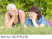 Mature beautiful couple in love on a green lawn in a park on a summer sunny day. Стоковое фото, фотограф Акиньшин Владимир / Фотобанк Лори